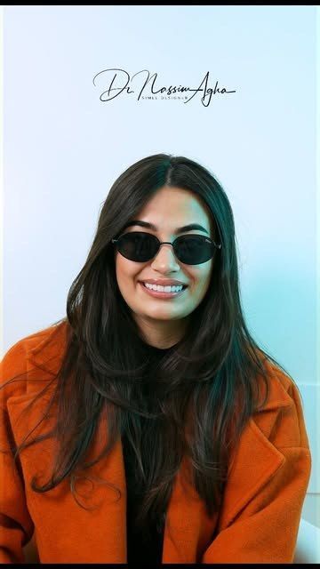 A patient of the clinic in sunglasses and an orange coat, smiling