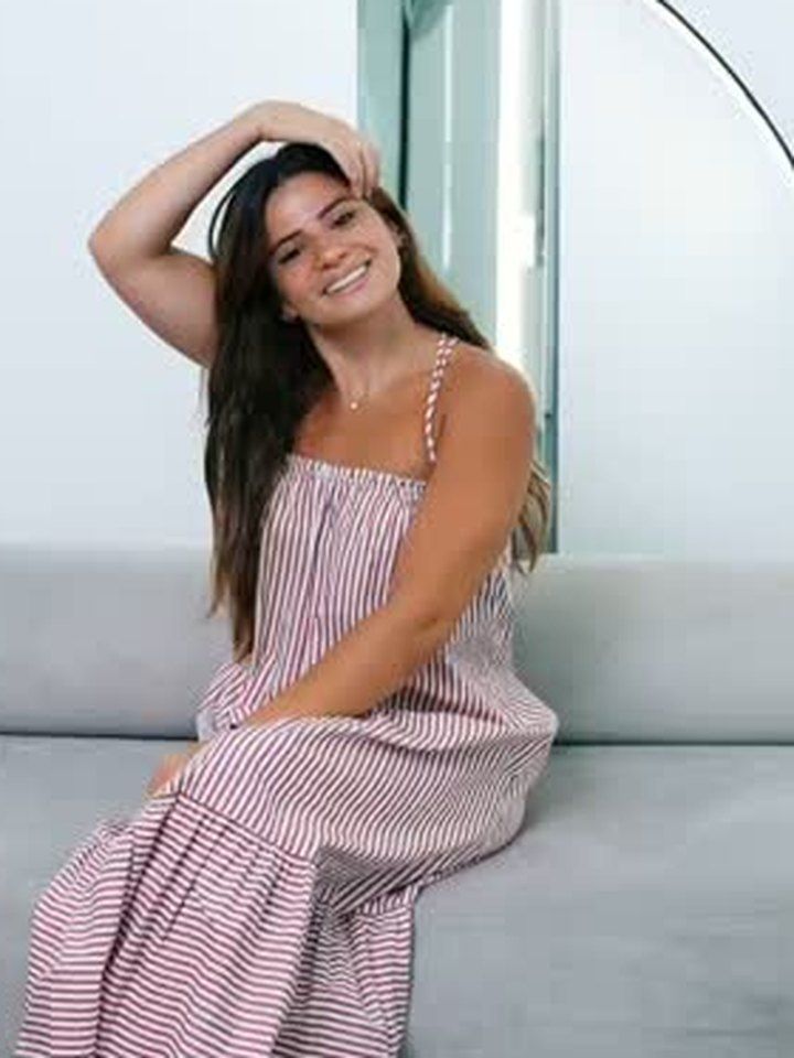 A patient of the clinic smiling on the waiting-room sofa